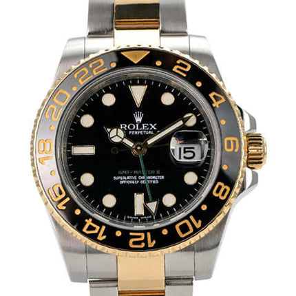 Rolex GMT-Master II 116713LN mit schwarzem Zifferblatt und goldener Lünette, Edelstahl- und Goldarmband.