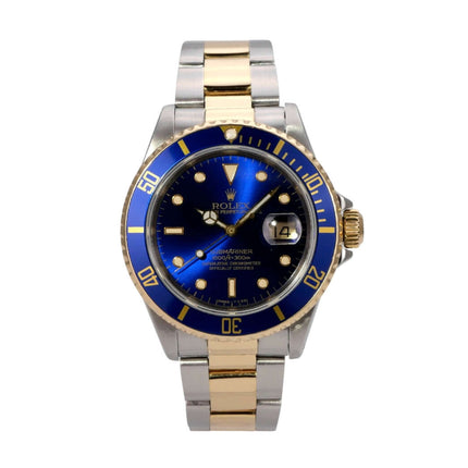Rolex Submariner Date 16613 Edelstahl Gold Blau im Vordergrund, Edelstahl- und Goldarmband, blaues Zifferblatt.