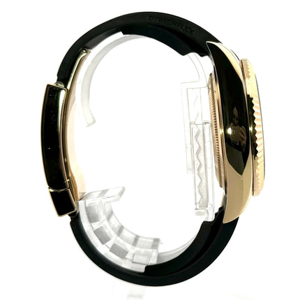 Seitenansicht der Rolex Sky-Dweller Gelbgold 326238 mit schwarzem Oysterflex-Armband und geriffelter Lünette.