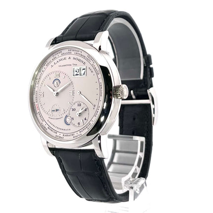 A. Lange & Söhne Lange 1 Zeitzone Platin 116.025 mit silbernem Zifferblatt und schwarzem Alligatorlederarmband auf weißem Hintergrund